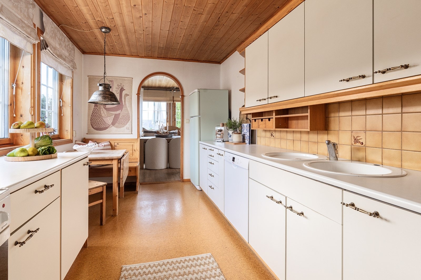 Innredningen består av folierte skrog med slette fronter og laminert benkeplate. Fliser på vegg i sprutsone ved komfyr og servant. Galleribilde