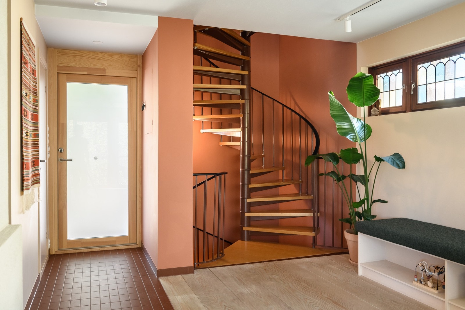 Innbydende entré med foliert glassdør for gjennomlys og en elegant original spiraltrapp som forbinder etasjene. Galleribilde