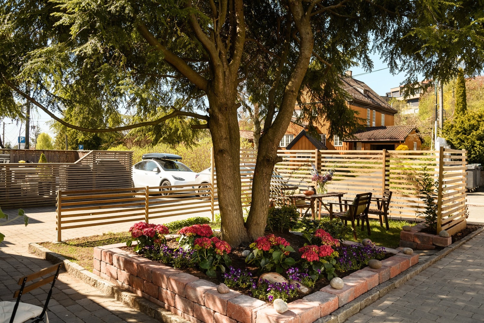 Pent opparbeidet forhage med beplantning og plass til en liten sittegruppe. Galleribilde