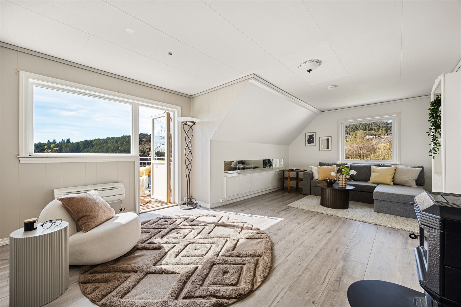 Loftstuen på 23m² med god plass til en koselig sofagruppe | Stuen har egen vedovn, varmepumpe og utgang til balkong Galleribilde