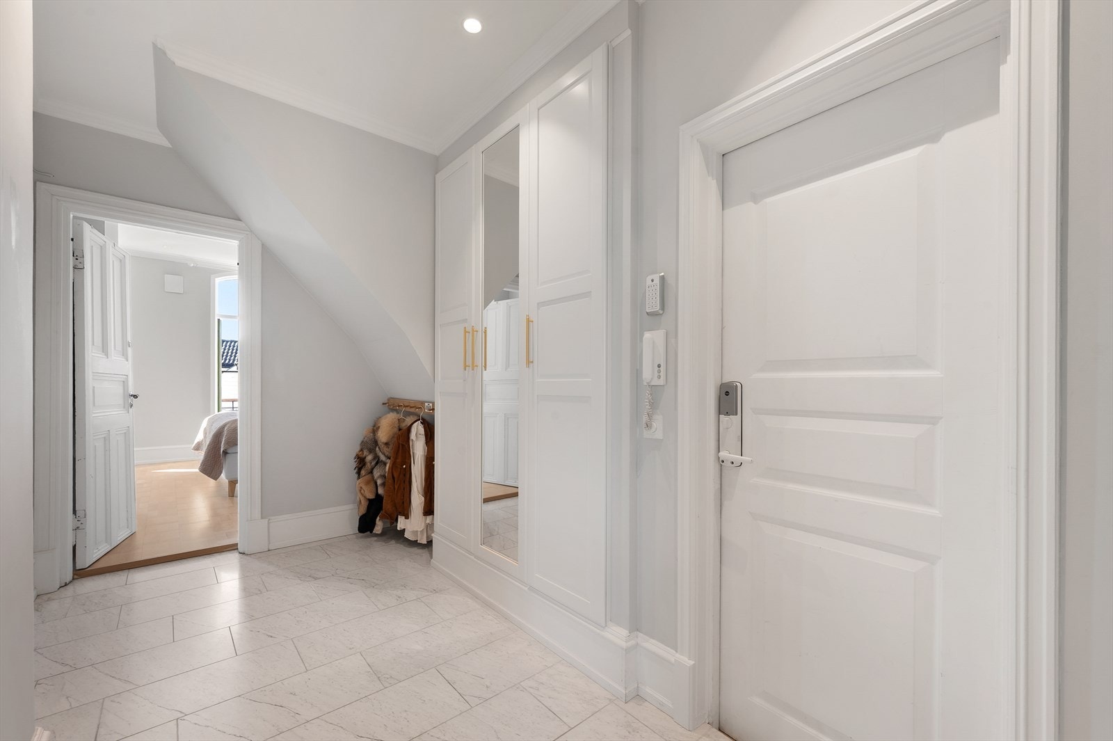Entréen er malt i lyse farger og har downlights i himling. Det er etablert en garderobe med oppbevaring til klær og sko Galleribilde