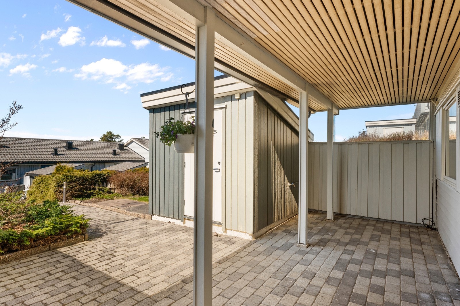 Overbygget uteplass med belegningsstein og gode soner for møblering. Galleribilde