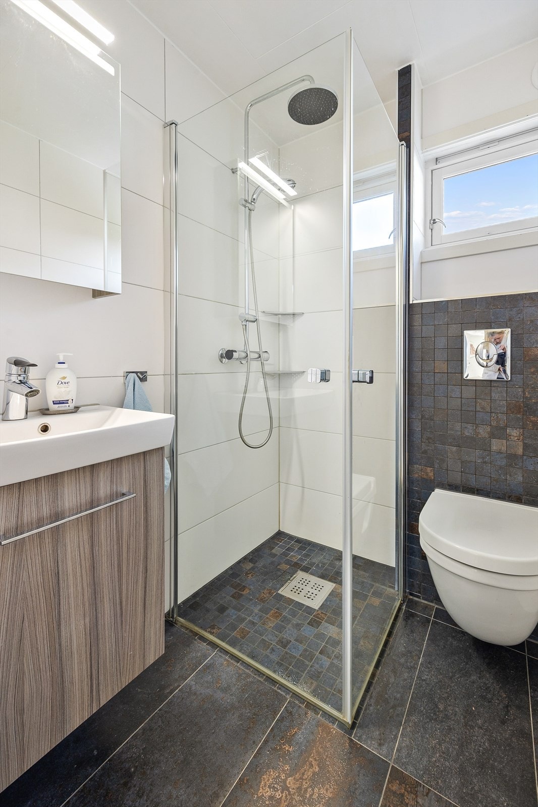 Badet i første etasje er flislagt og har gulvvarme. Rommet er utstyrt med vegghengt toalett og dusjhjørne. Galleribilde