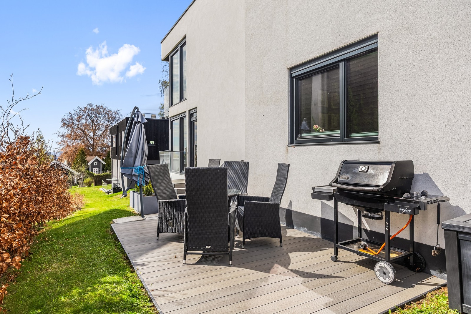 Terrasseplattingen har direkte adkomst fra stuen og videre til en liten gressplen Galleribilde