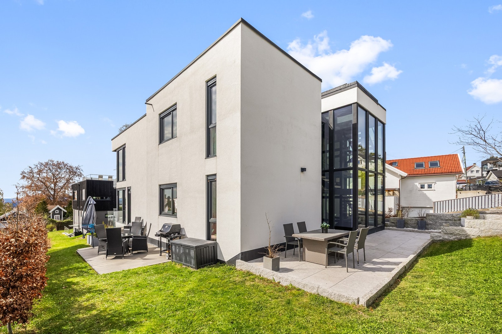 Pent opparbeidet uteområde | Denne seksjonen disponerer terrasseplattingen og gressplenen på venstre side av bilde, høyre side er fellesområde og inngangsparti Galleribilde