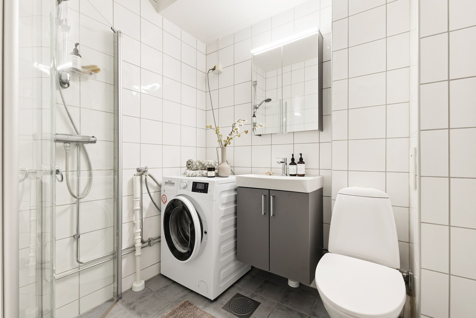Det flislagte badet et pusset opp i regi av borettslaget i 2006 og har en praktisk planløsning med dusj, toalett og servantinnredning. Galleribilde