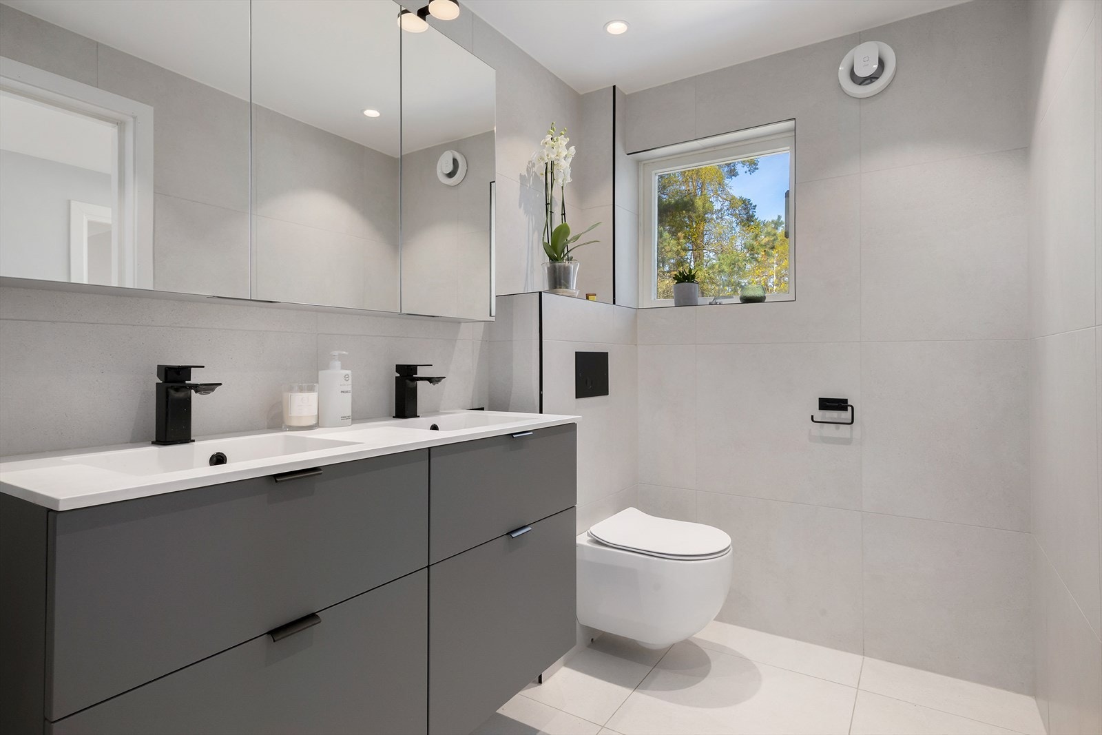 Badet har store fliser på gulv og vegger, downlights i himling og behagelig gulvvarme. Galleribilde