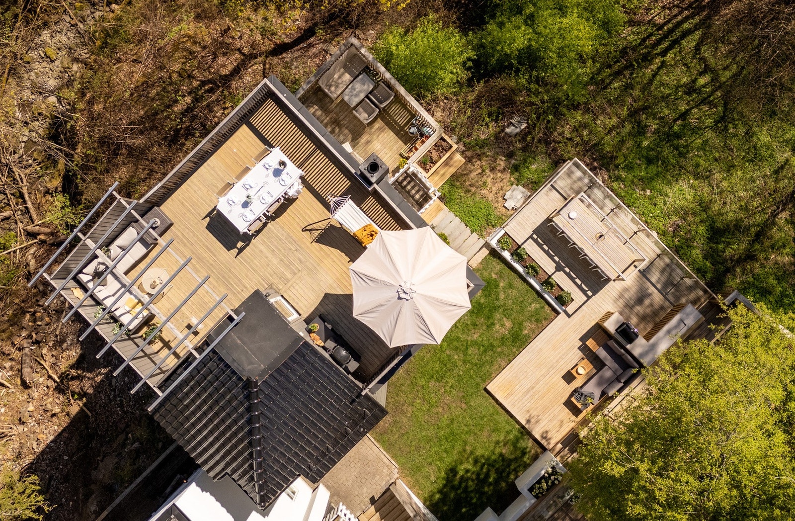 Boligen har fantastiske uteplasser på totalt 146 kvm, fordelt på terrasse fra underetasjen, hagedel med frittliggende terrasse og utekjøkken, samt takterrasse. Galleribilde