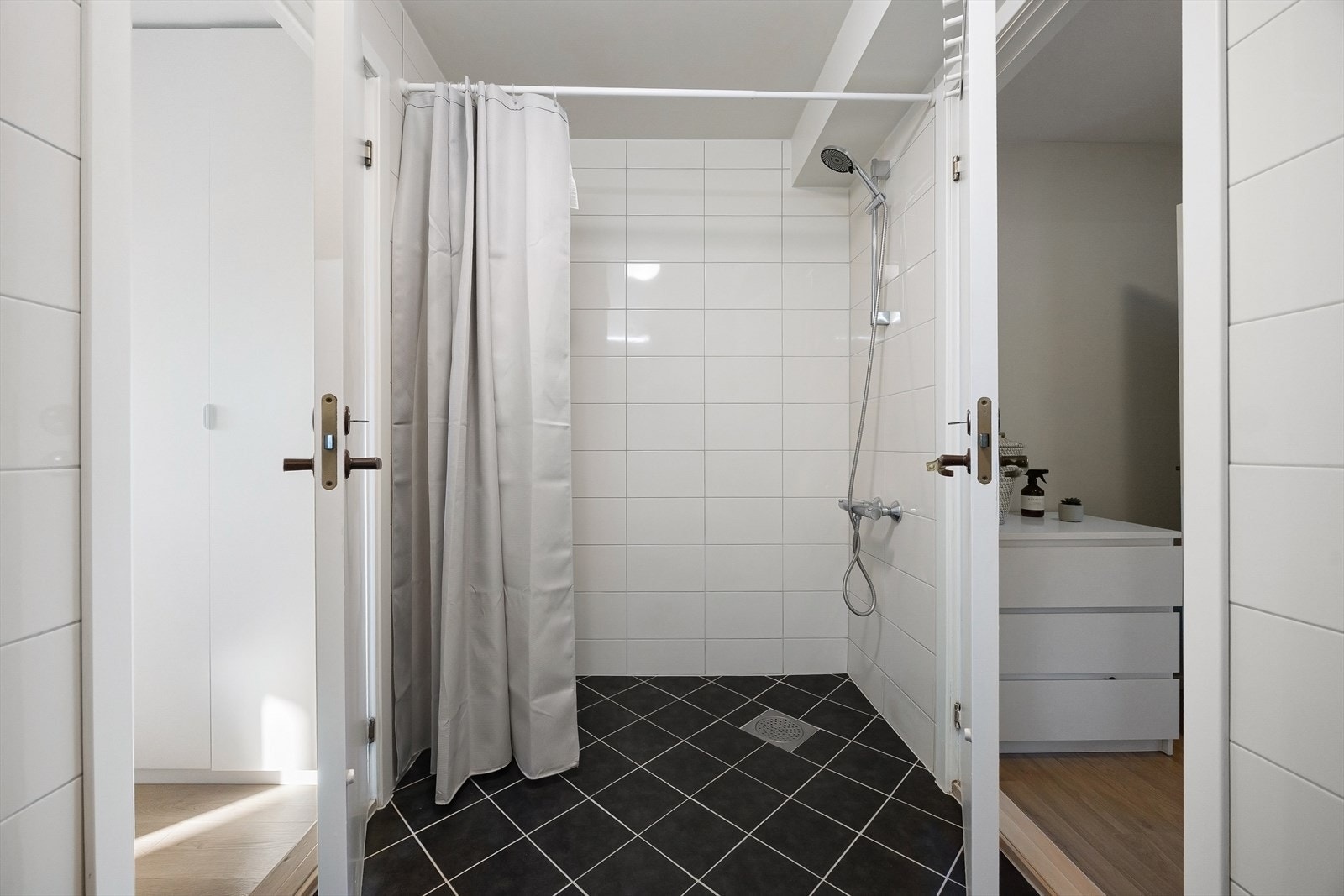 Badet er innredet med vegghengt servant med ett-greps blandebatteri, underskap, speilskap, gulvstående toalett, blandebatteri og dusjgarnityr. Galleribilde