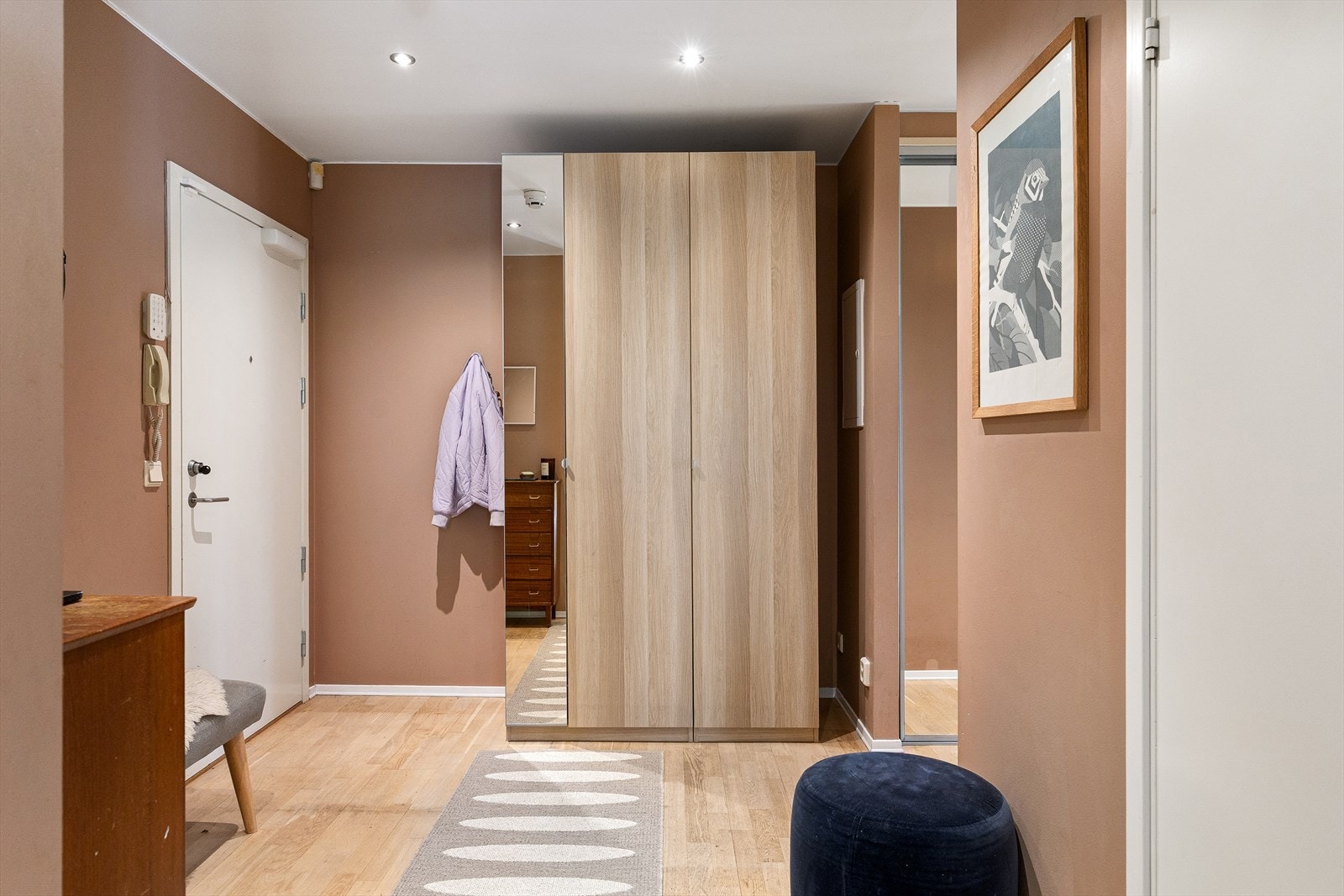 I entré/gangen er det rikelig med oppbevaringsplass til yttertøy i en romslig skyvedørsgarderobe med speilfronter, i tillegg til praktiske garderobeskap. Galleribilde