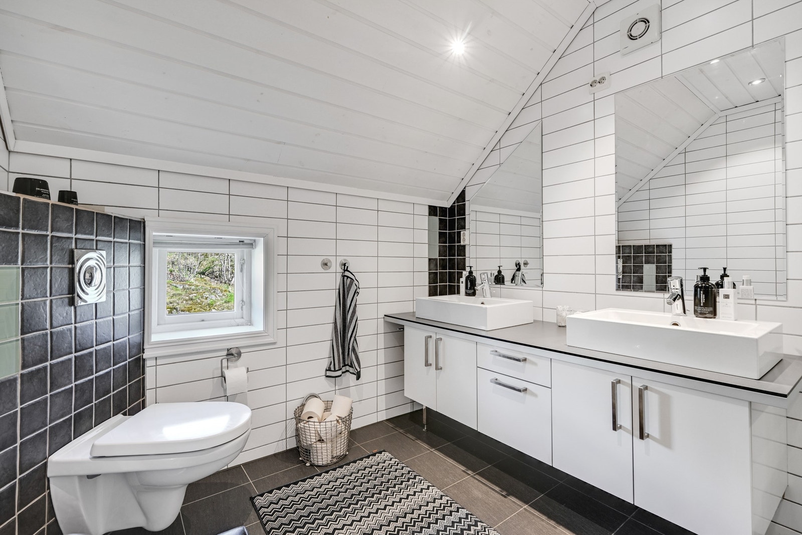 Badet har flislagte vegger og gulv, samt panel i taket. Galleribilde