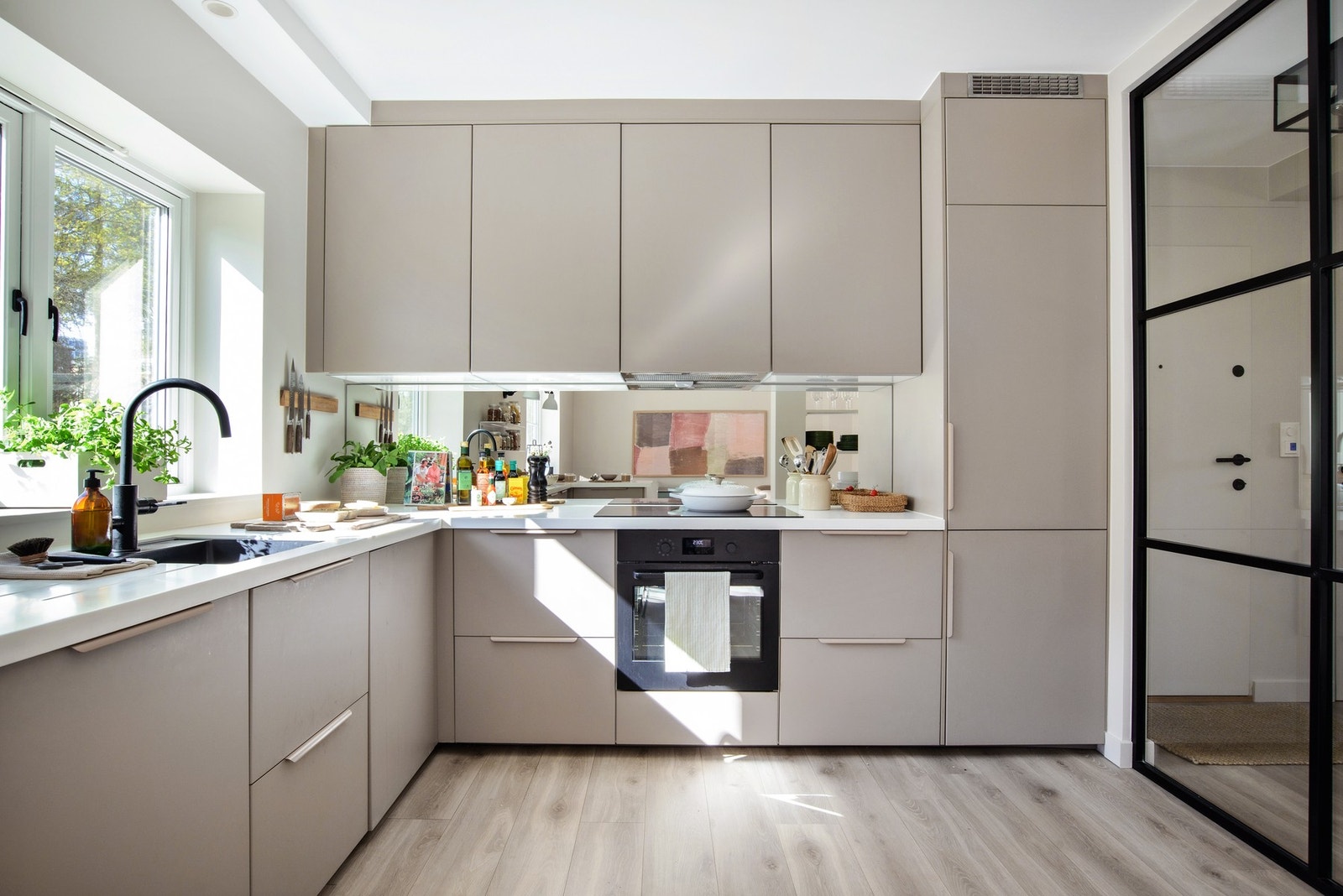 Kjøkkeninnredningen er en toppmodell fra IKEA med underlimt servant, skjulte stikkontakter og benkeplate i kompositt. Speilet over benken gir rommet et luftig preg. Galleribilde