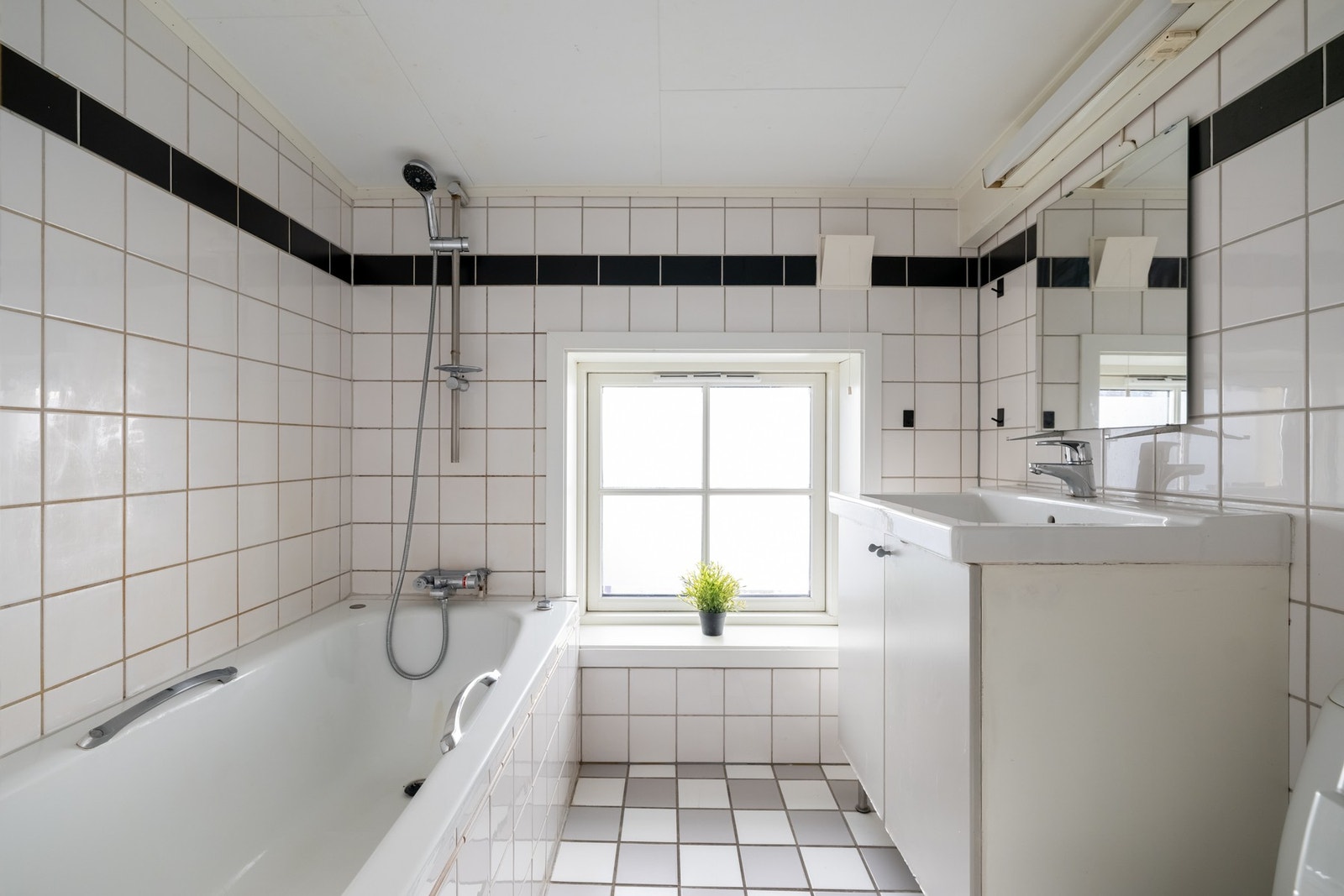 Lyst, flislagt bad med varme i gulv. Galleribilde