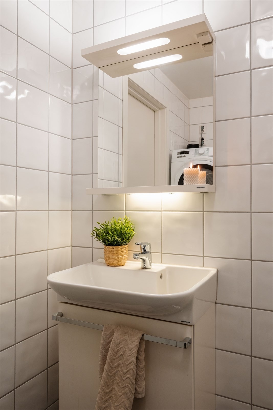 Badet er utstyrt med toalett, dusj, slett innredning, servant og speil med belysning. Galleribilde