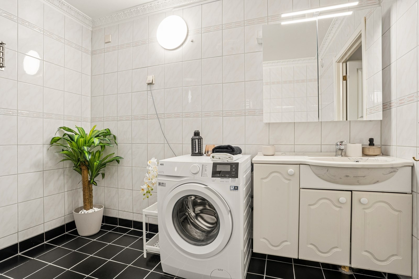 Badet er innredet med servantskap med ett-greps blandebatteri, speilskap, gulvstående toalett og dusjkabinett. Galleribilde