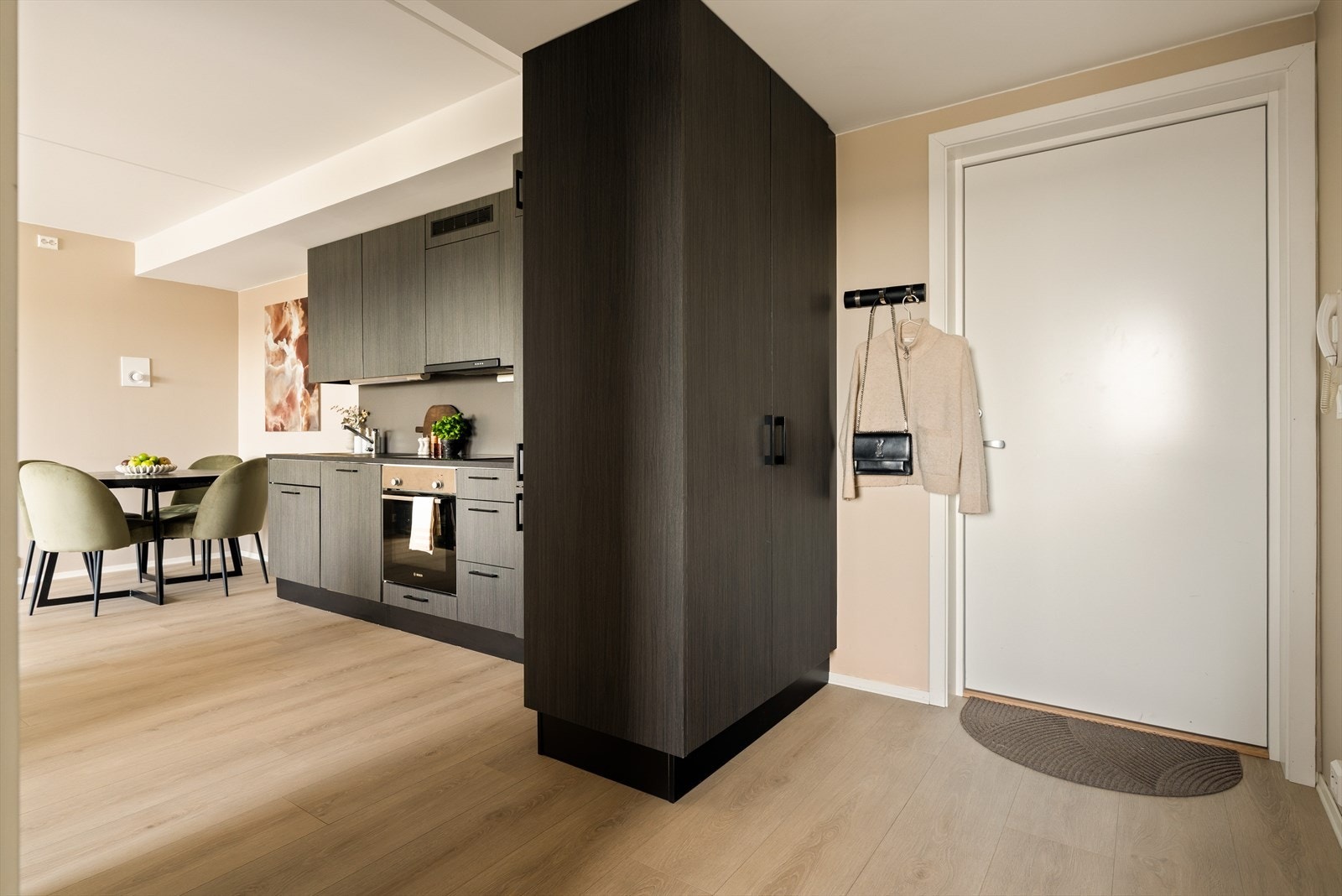 Velkommen inn! En lekker entré sørger for et godt førsteinntrykk. Her er det rikelig med plass til oppbevaring. Garderobeskapet står i stil med samtidig som det fungerer som et naturlig skille mellom gang og kjøkken. Galleribilde
