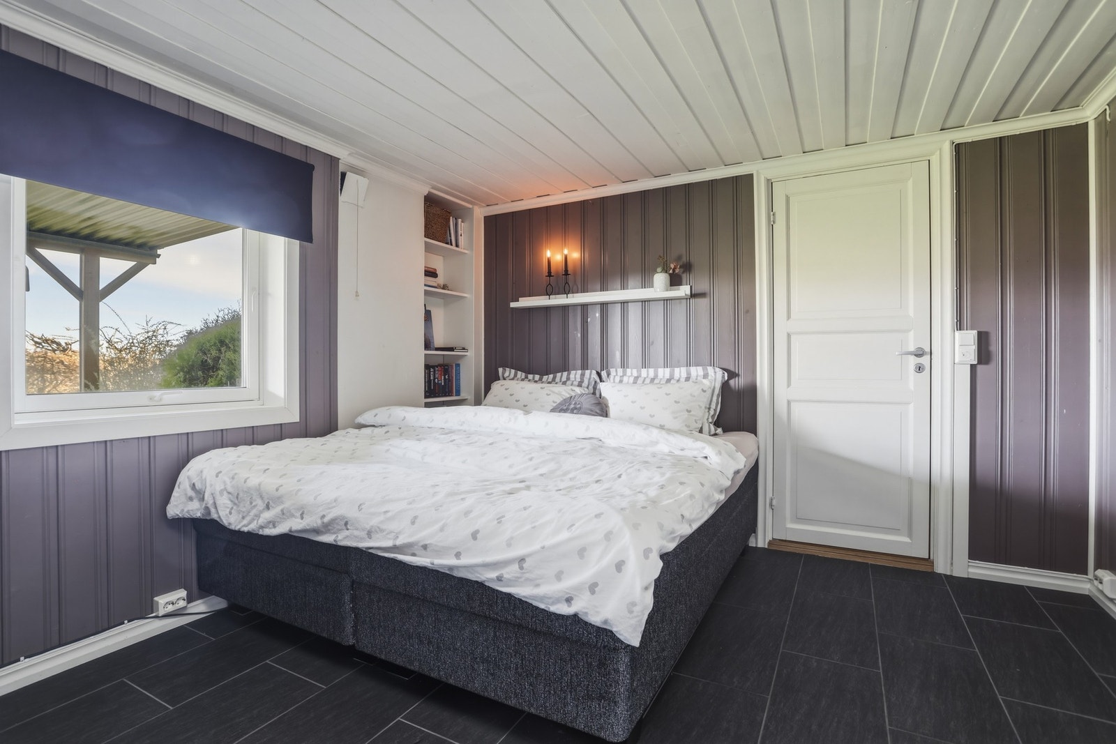 Del av kjellerstuen innredet med gjesteseng. Galleribilde
