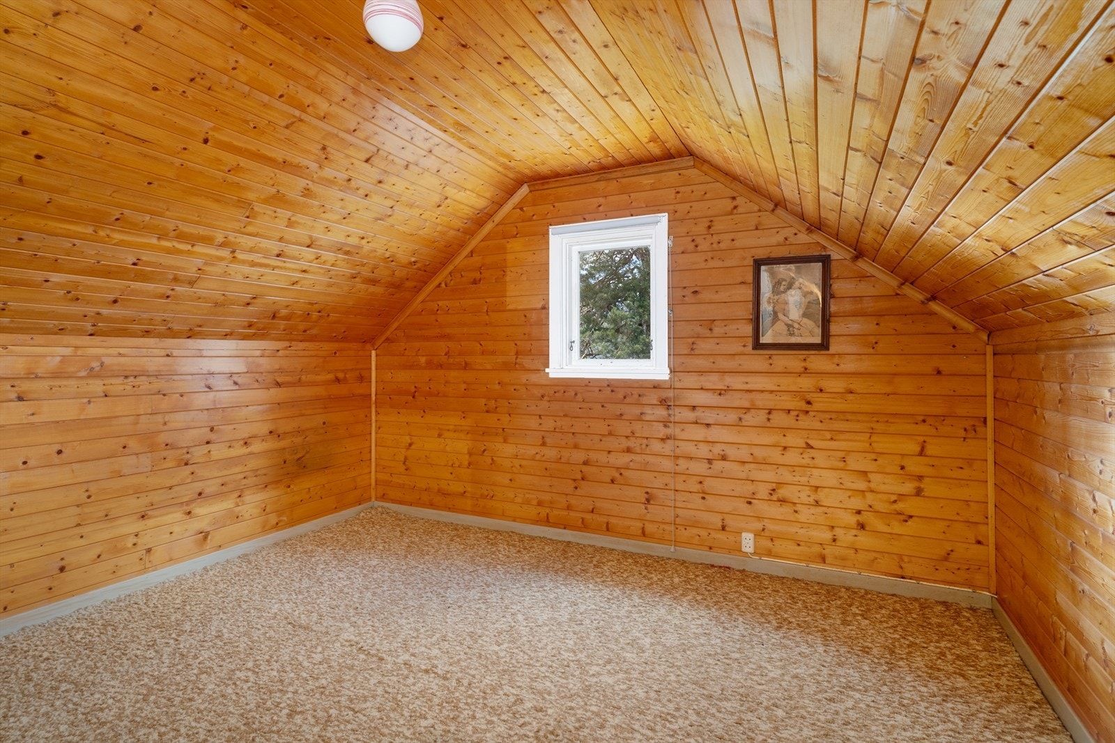 Ett av de tre loftsrommene, med trepanel på vegger og i tak. Galleribilde