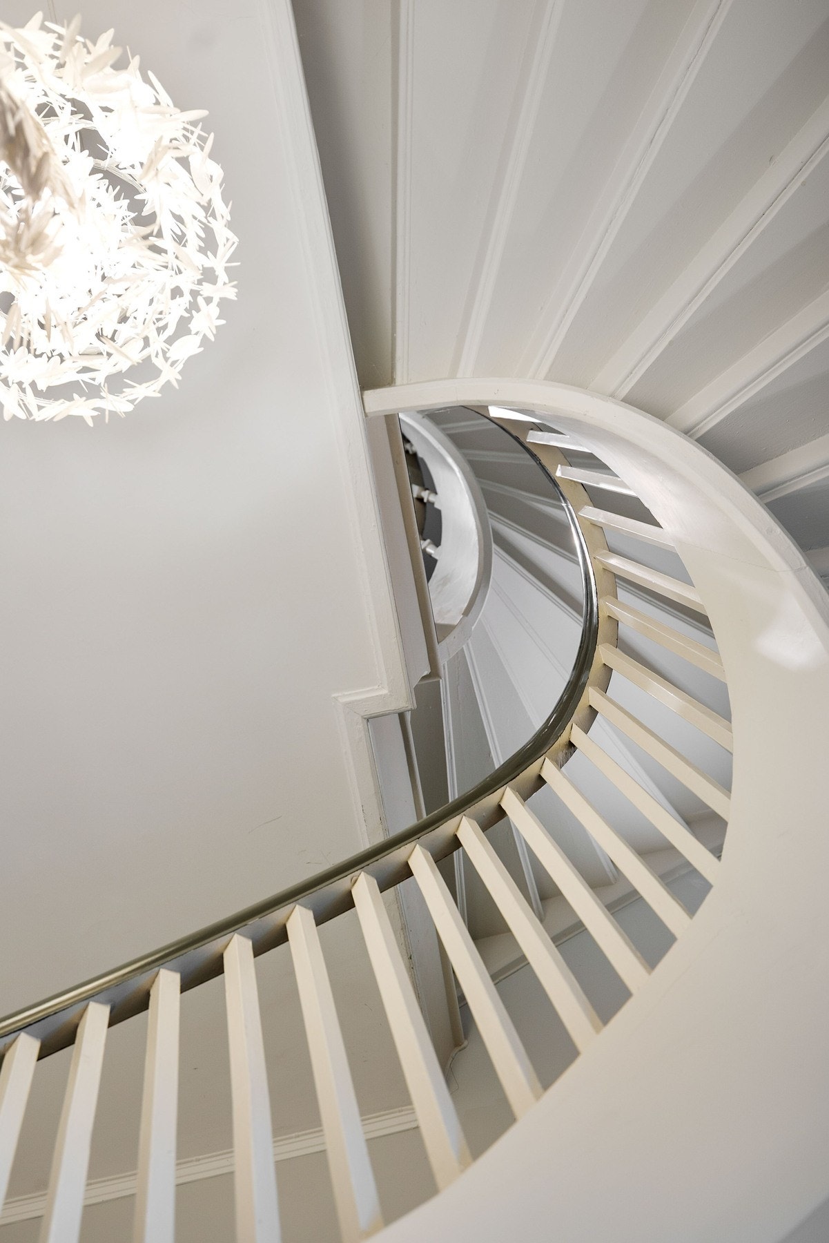 En elegant spiraltrapp med lyse farger og moderne design tar deg opp til boligen. Galleribilde