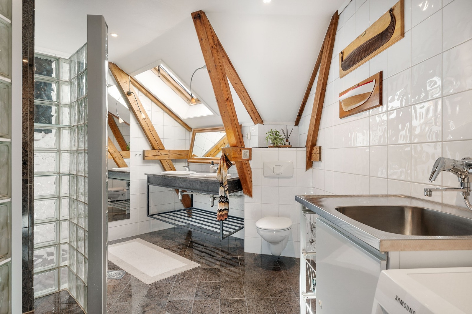 Badet er romslig og har overlys fra takvindu. Flislagt gulv og vegger, samt dusj med larvikittfliser. Galleribilde