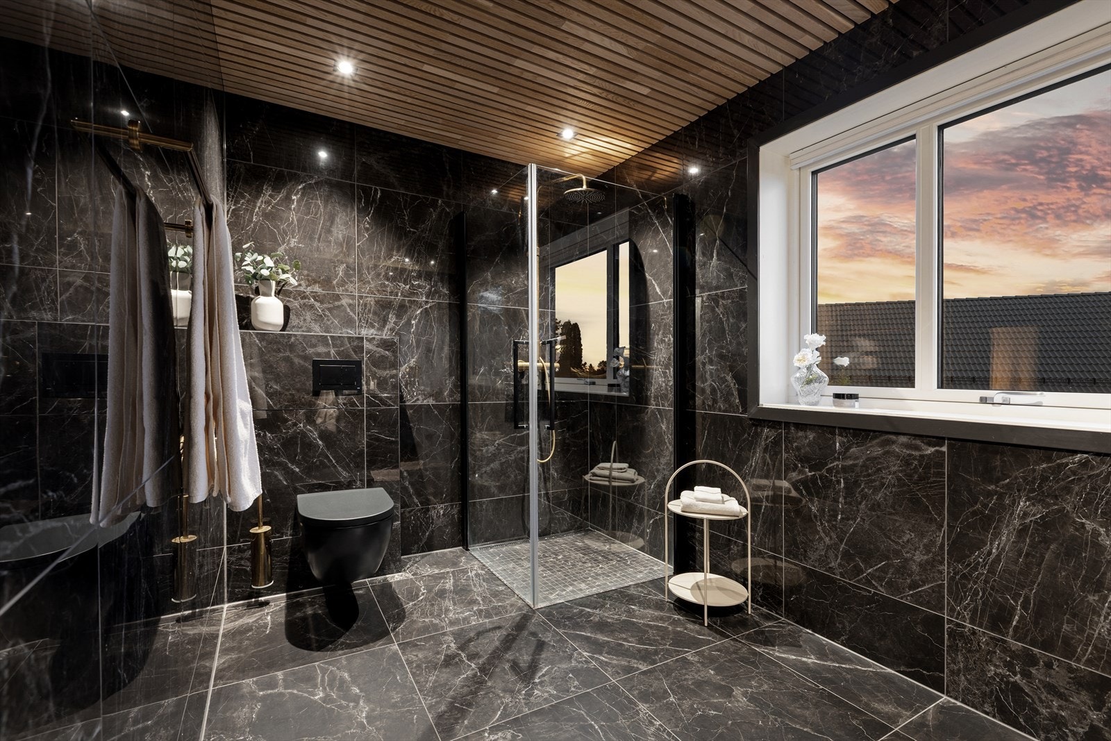Hovedbadet i andre etasje har et eksklusivt uttrykk med mørke fine detaljer, store fliser og spiletak. Galleribilde