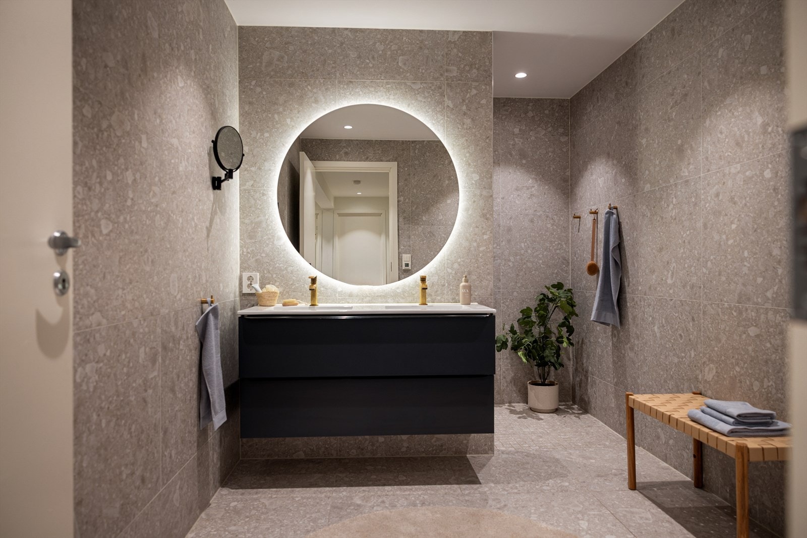Badet i første etasje er flislagt og utstyrt med en bred servantinnredning. Galleribilde