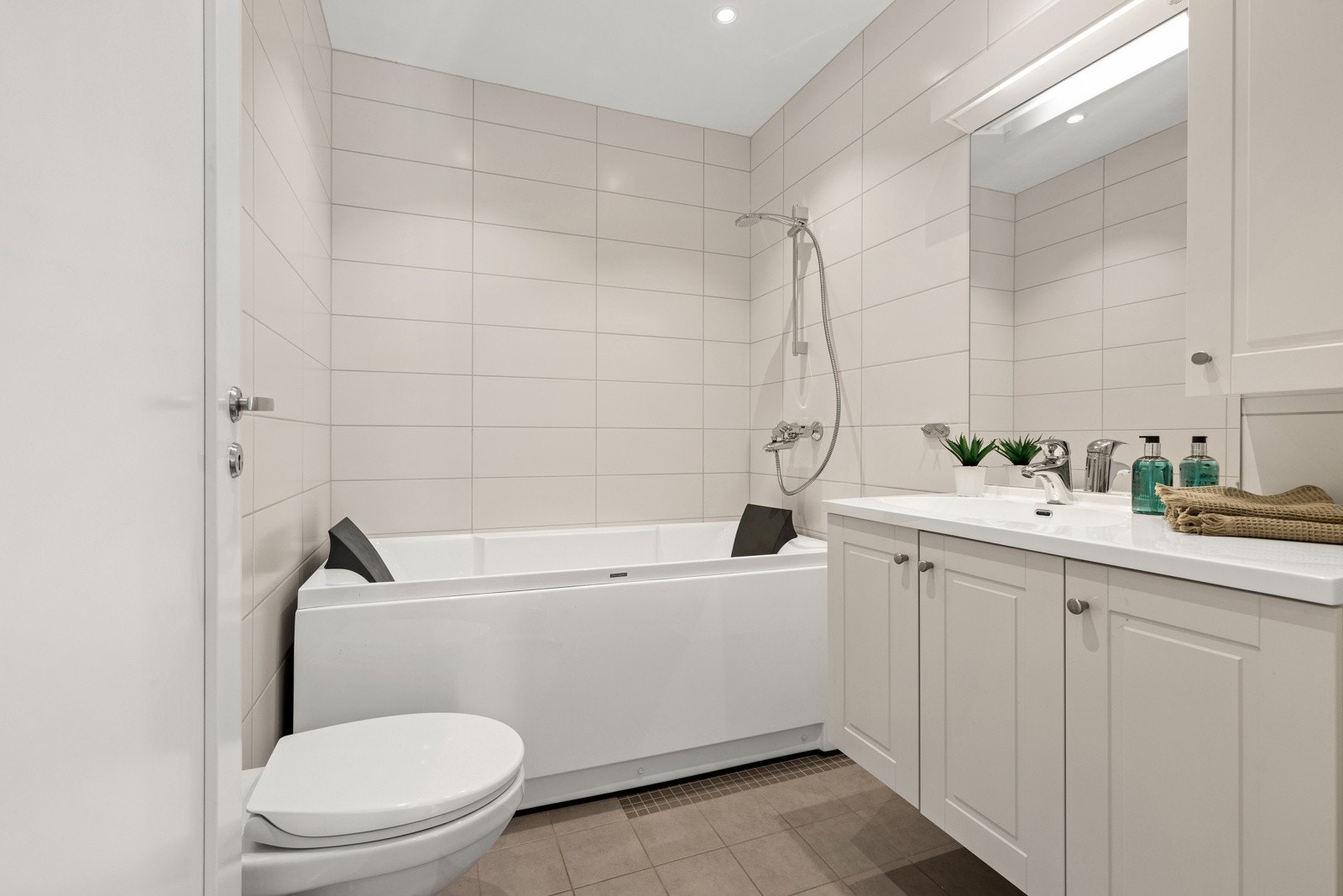 1 av 3 bad. Dette badet har badekar og dusj på vegg. De to andre badene har dusj Galleribilde