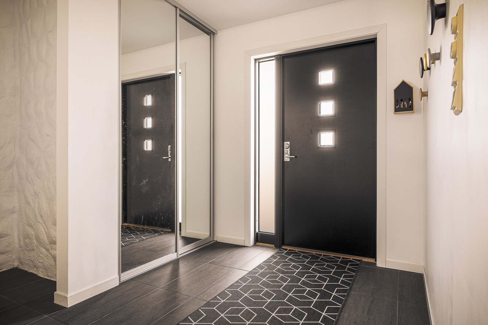 Inngangspartiet leder inn til en romslig hall på 25,5 m² i boligens første etasje | Galleribilde