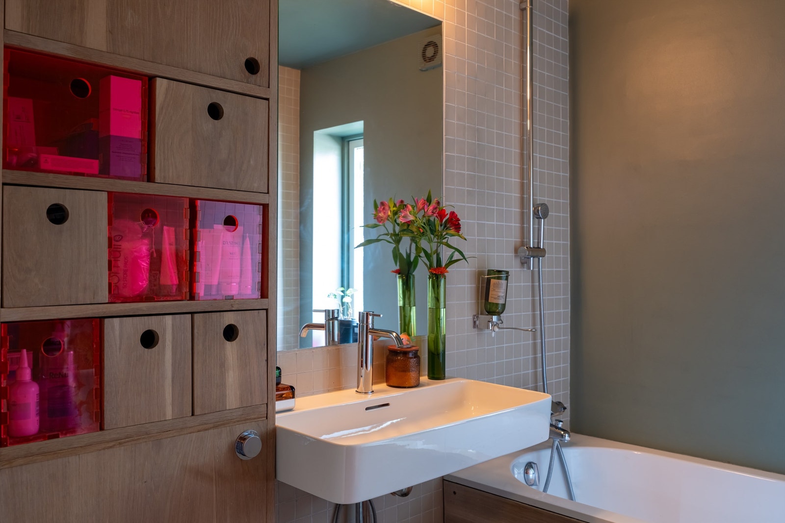 Badet er innredet med servant med speil og lys over vasken. Galleribilde