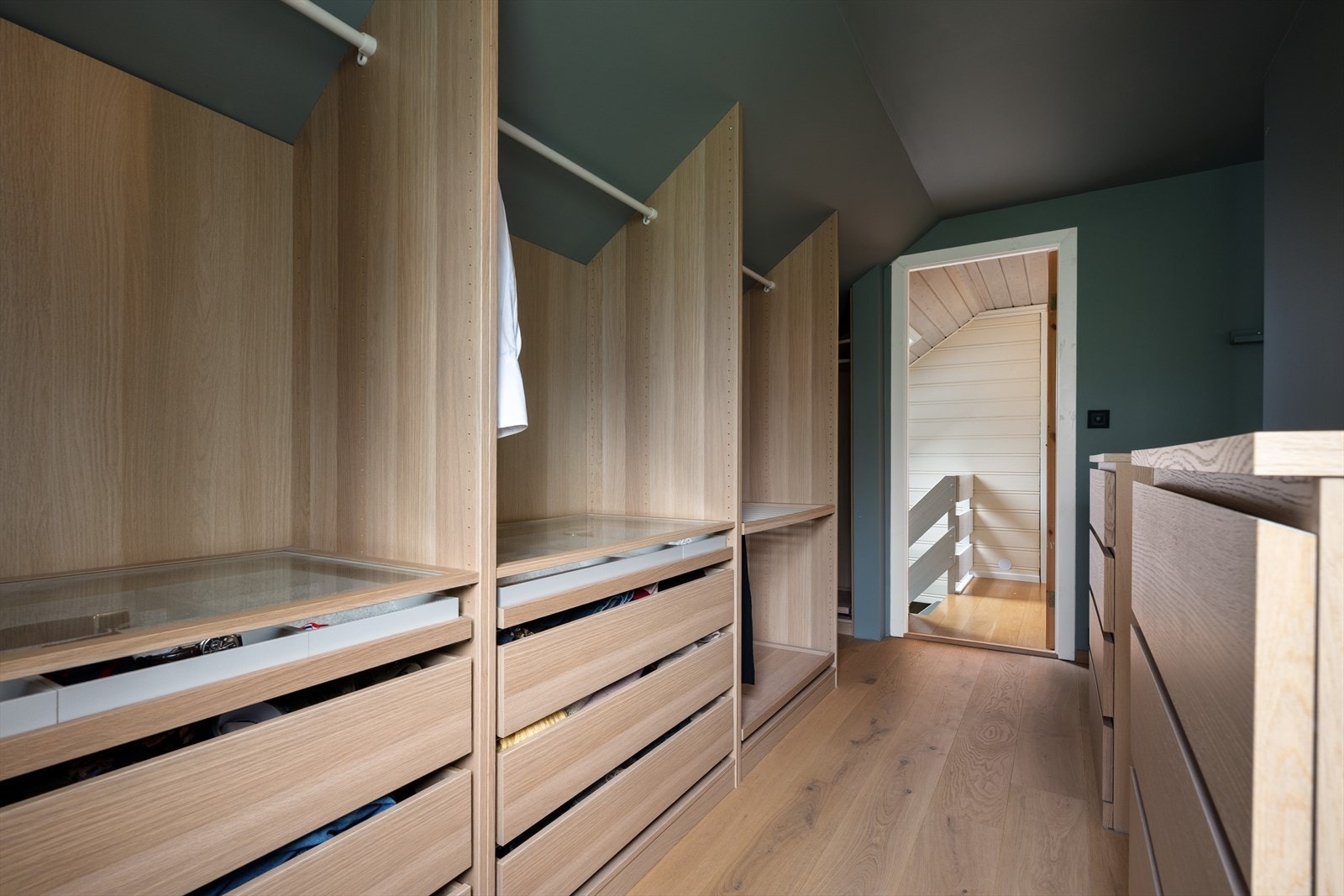 Romslig walk-in garderobe med plassbygd Ikea Pax-garderobeskap i eik. Galleribilde