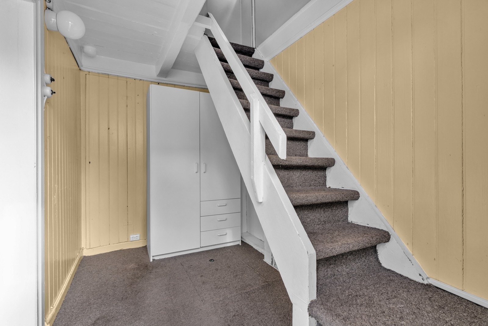 Velkommen inn! Vindfang med teppe på gulv og panel på veggene. Inngang til bod og stue. Galleribilde