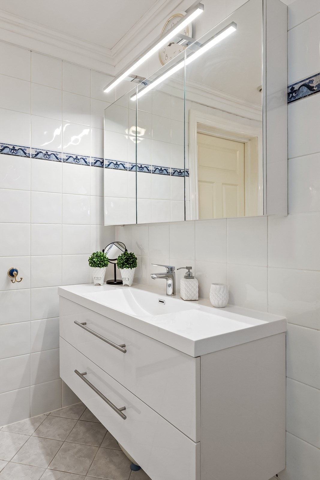 Badet har en moderne servantinnredning og speilskap med integrert belysning og stikkontakt. Galleribilde