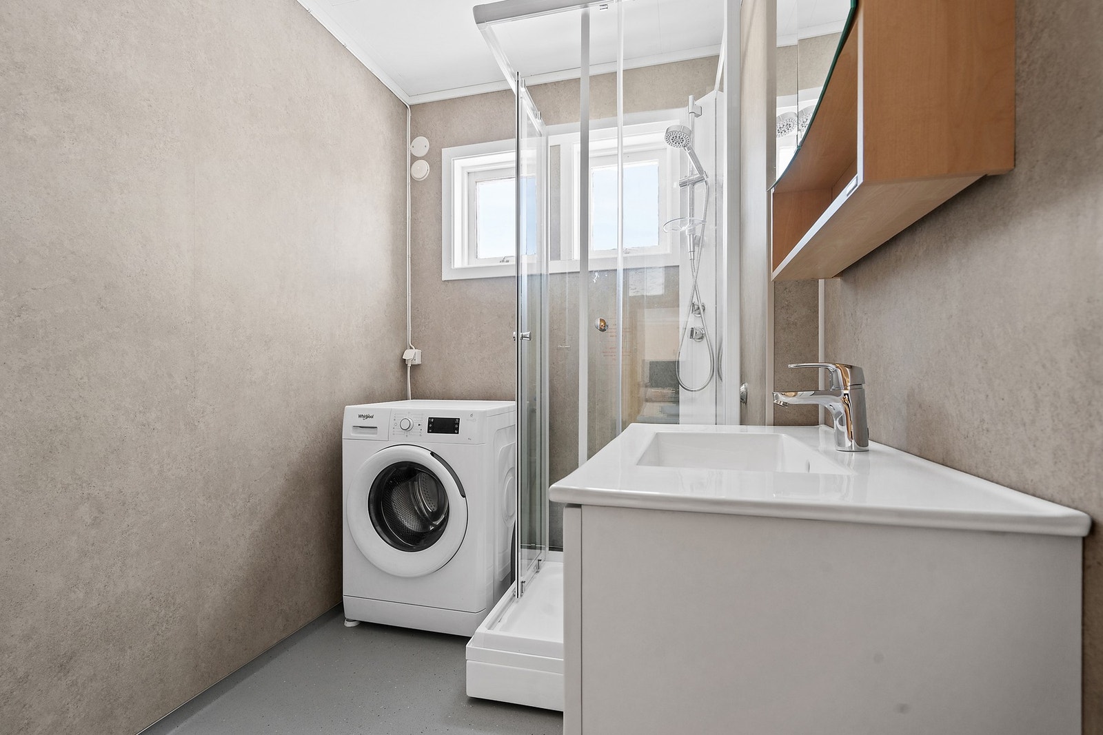 Badet i hovedetasjen har baderomsplater på veggene og vinylbelegg på gulvet. Galleribilde