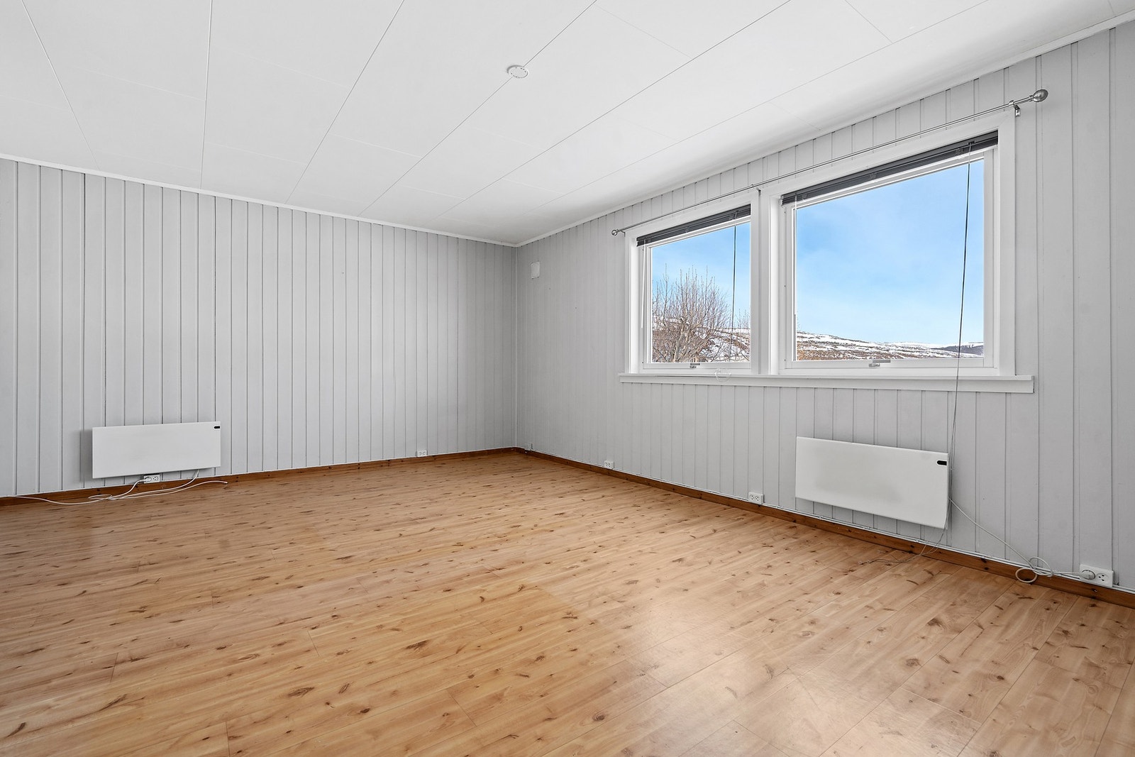 Stuen i utleiedelen har panel på veggene og laminatgulv. Galleribilde
