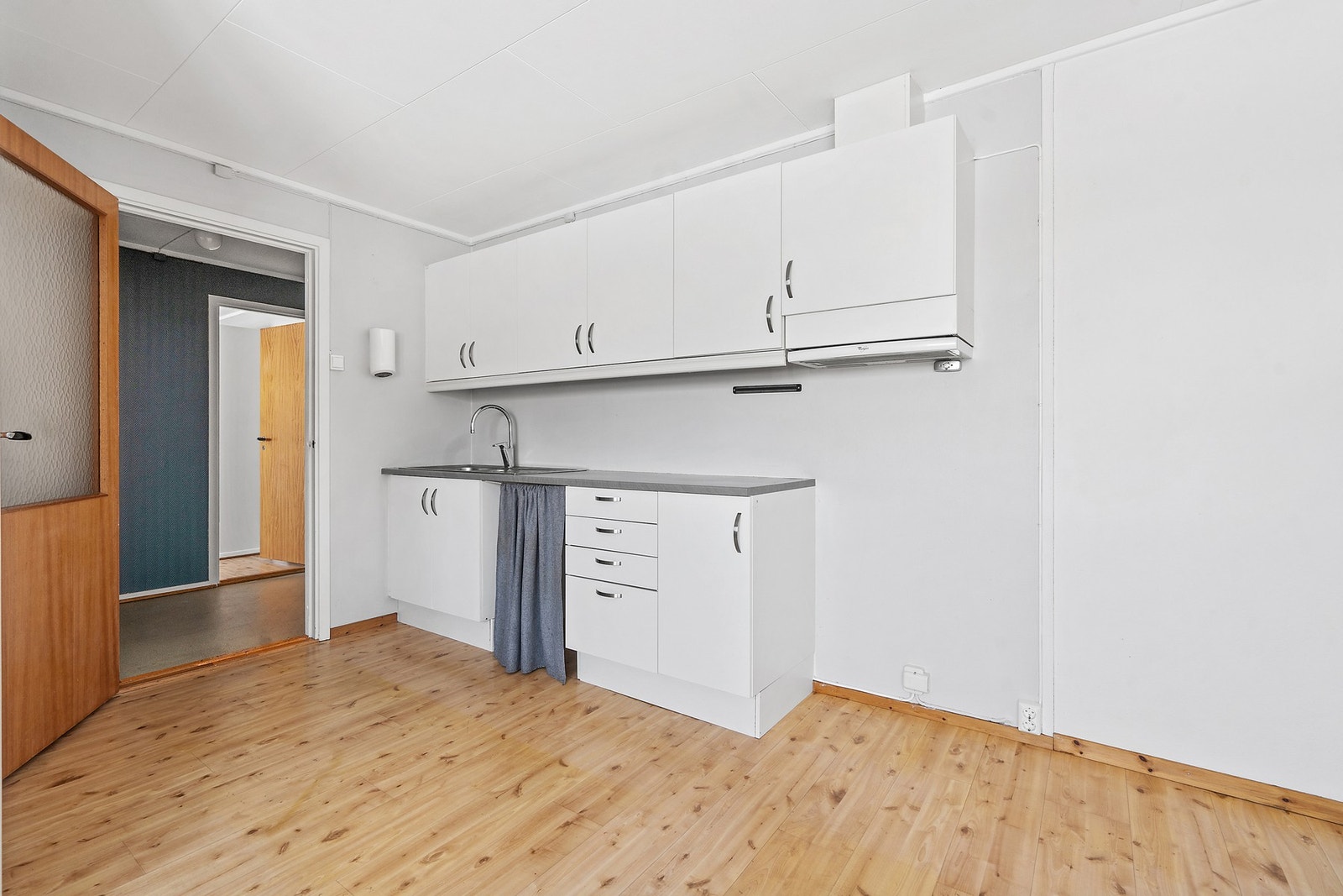 Praktisk kjøkkenkrok med laminatbenkeplate og kjøkkenventilator med avtrekk ut. Galleribilde