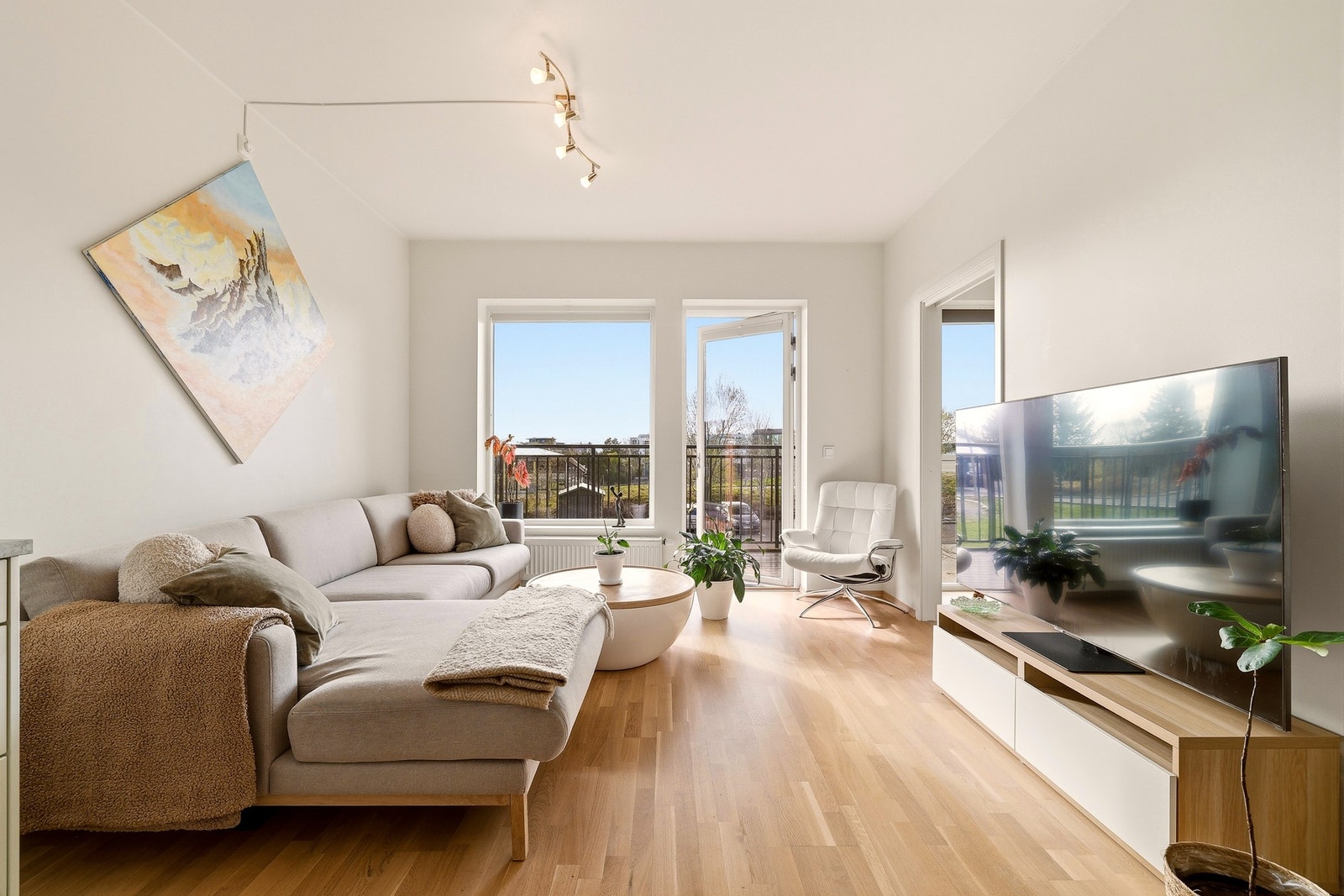 Lys og innbydende stue med store vindusflater som slipper inn rikelig med naturlig lys og skaper en luftig og behagelig atmosfære. Galleribilde