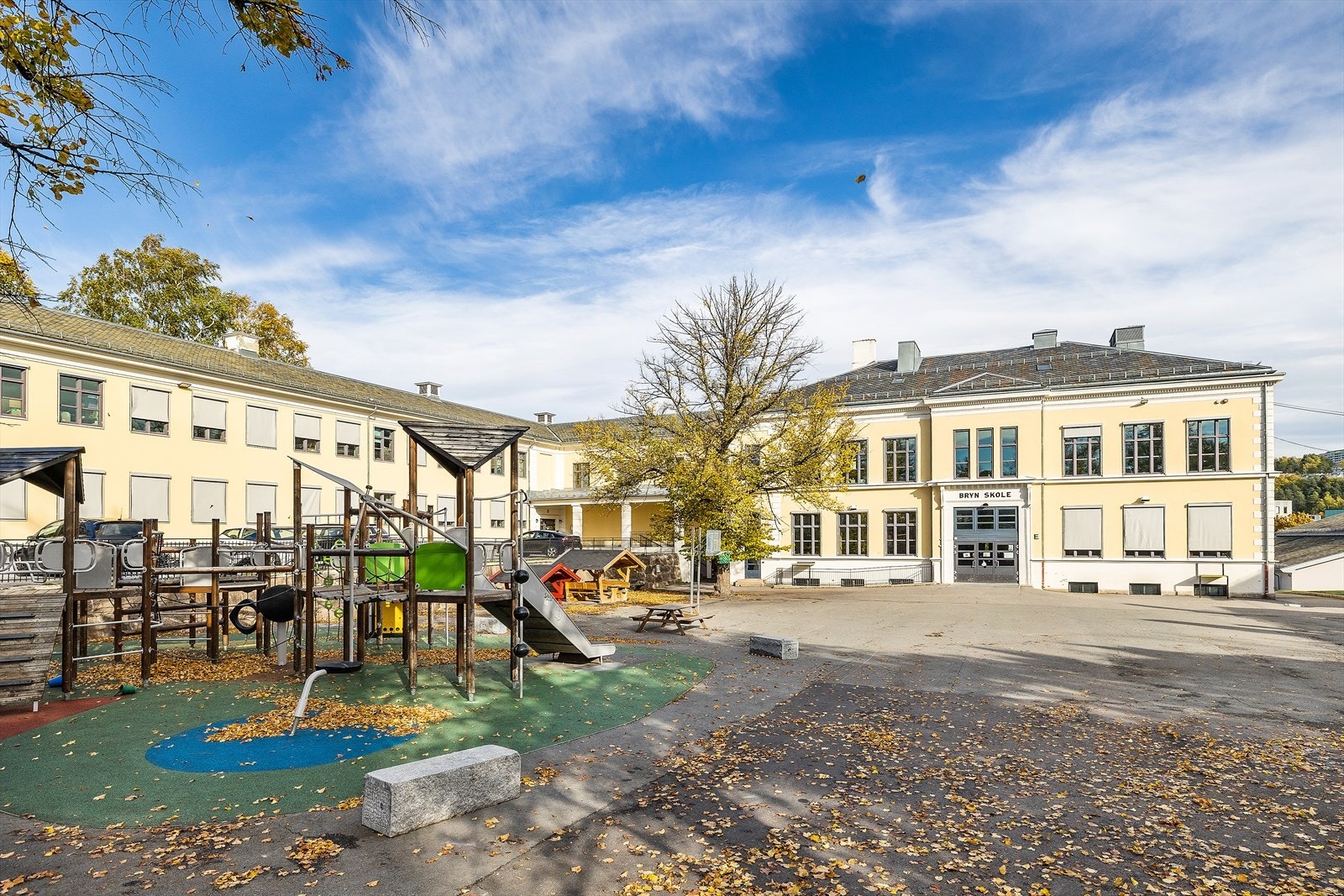 Skolegård med lekeapparater gir et trygt sted for barnas aktiviteter. Galleribilde