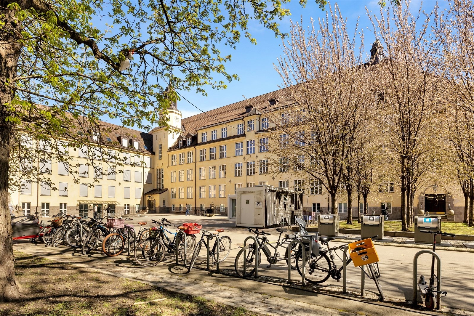 Urban beliggenhet med etablert bybebyggelse, trerekker og sykkelparkering i nærområdet Galleribilde