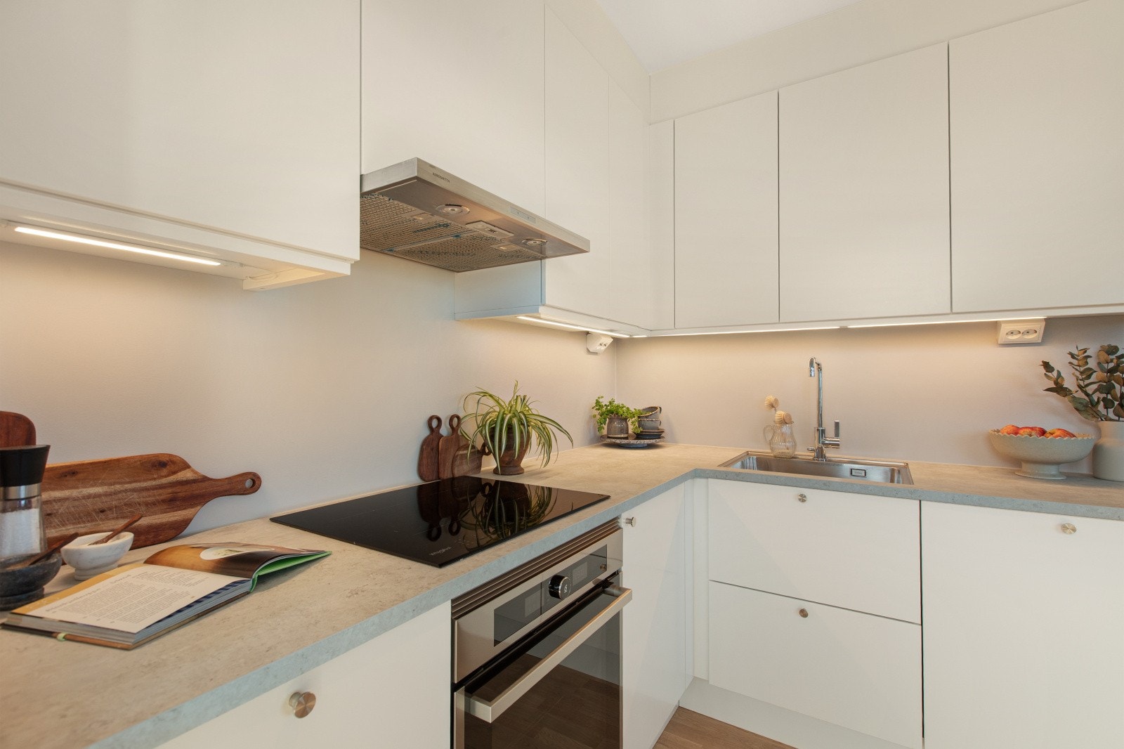 Kjøkkenet er stilrent og funksjonelt, med glatte fronter og hvitevarer som komfyr, koketopp, oppvaskmaskin og kombinert kjøl/frys som følger. Galleribilde