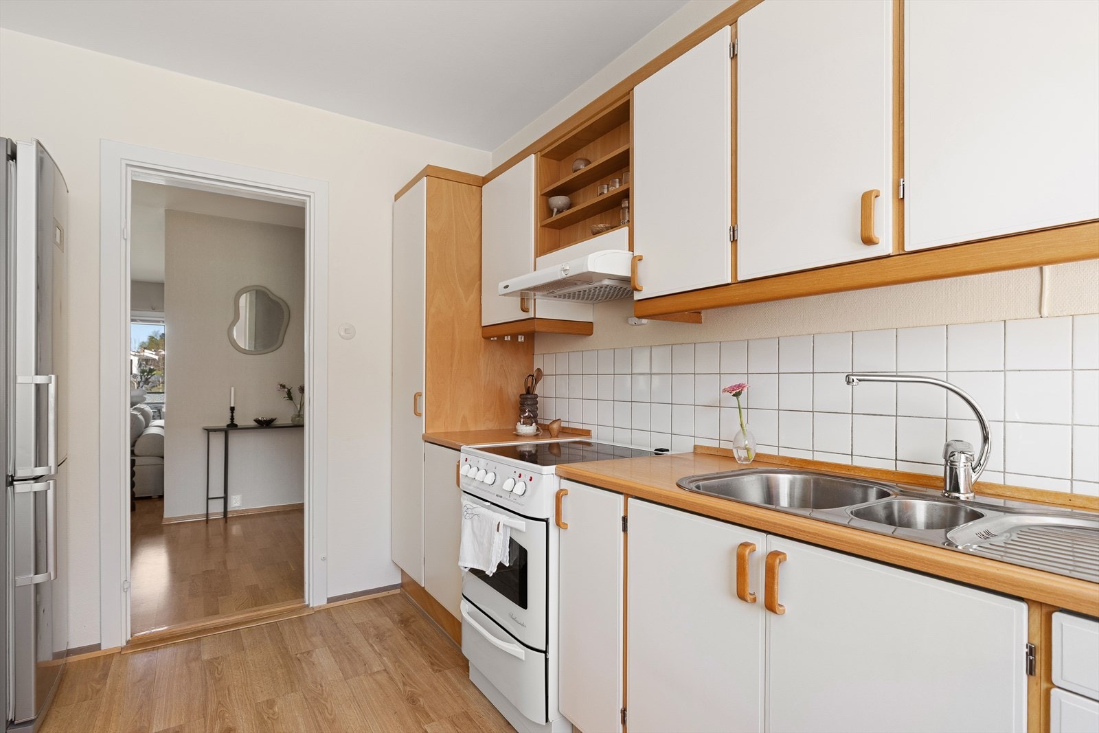 Kjøkkenet har laminat benkeplate med oppvaskkum og ettgreps blandebatteri. Fliser mellom benkeplate og overskap. Benkebelysning under overskap. Det er montert komfyrvakt. Galleribilde