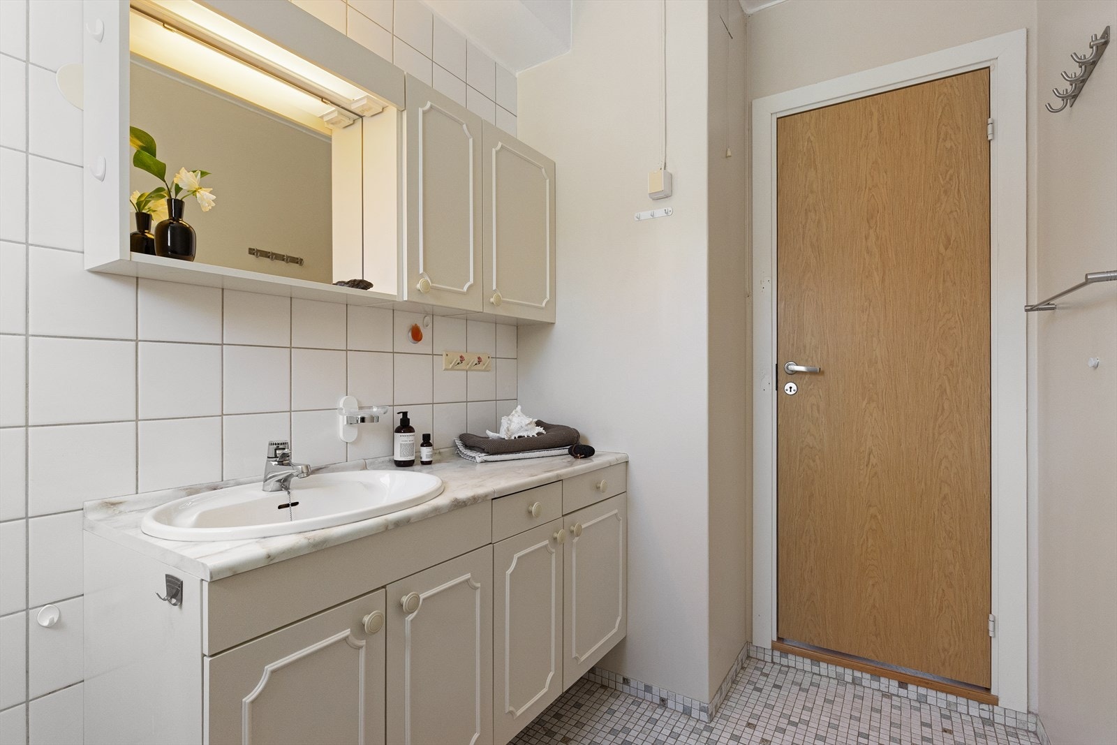 Lyst hovedsakelig originalt baderom med mosaikkfliser og varmekabler på gulv. Fliser og malt mur på vegger. Malt betonghimling. Galleribilde