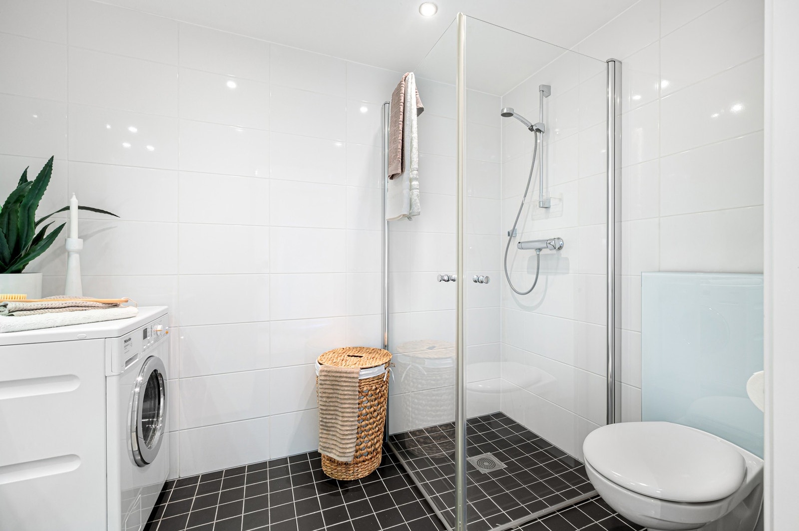 Vegghengt toalett på badet og dusjnisje med plassbesparende innfellbare dører. Galleribilde
