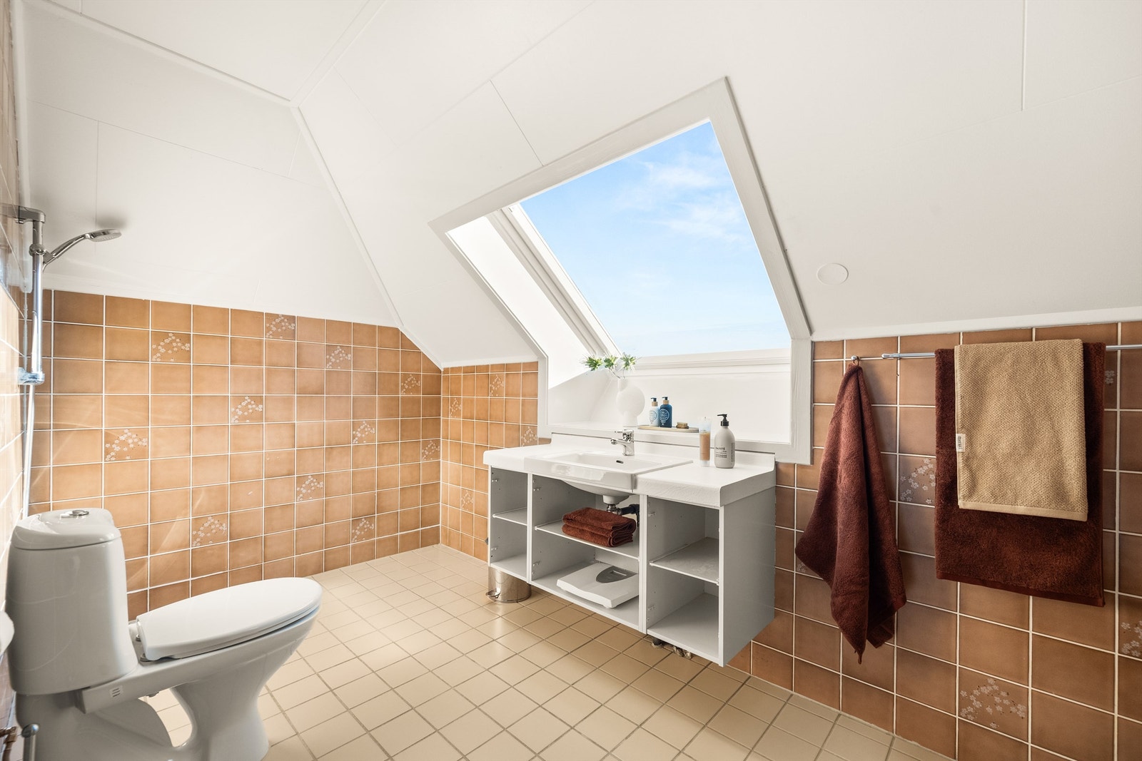 Badet på loftet har flislagt gulv med gulvvarme og et stort takvindu som gir rikelig med dagslys. Galleribilde