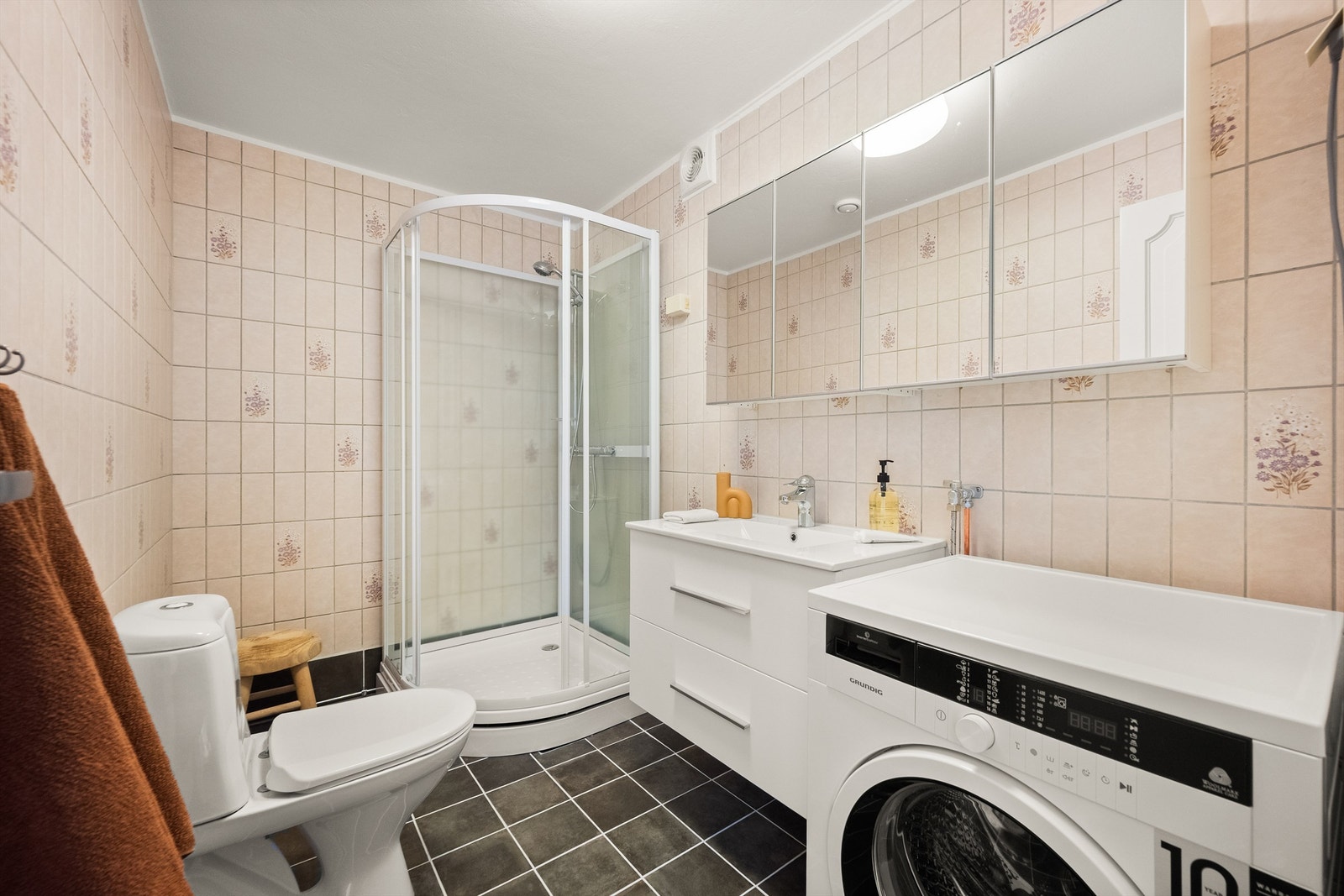 Badet i den minste delen/leilighten er flislagt, har gulvvarme, dusjkabinett og opplegg for vaskemaskin. Galleribilde