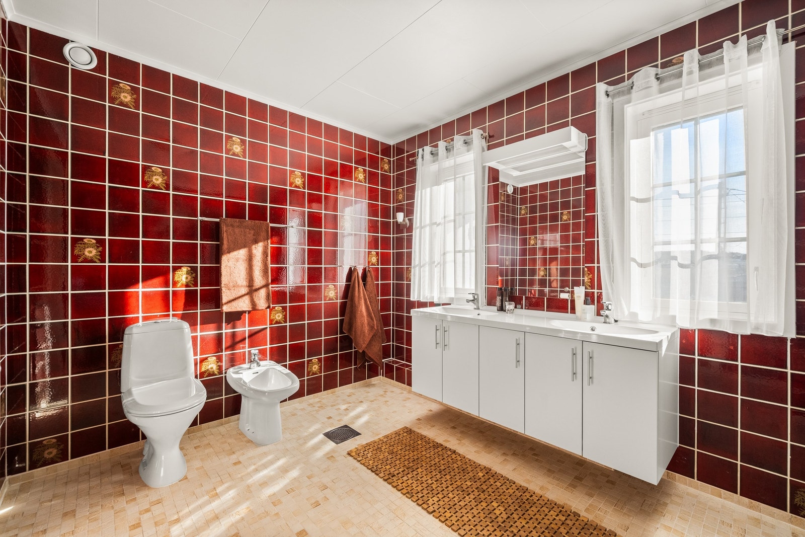 Badet er romslig, med flislagt gulv med gulvvarme, bidet og en bred servantinnredning med doble servanter. Galleribilde