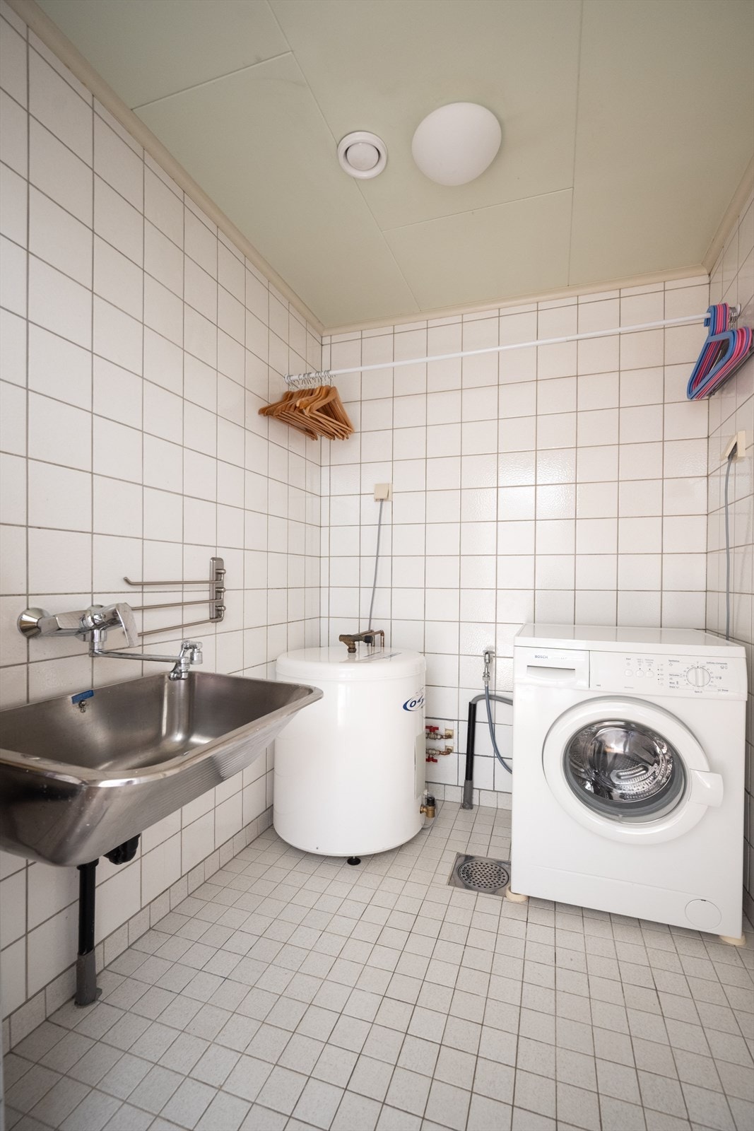 Eget vaskerom med flislagt gulv med gulvvarme, utslagsvask og opplegg for vaskemaskin. Vaskemaskin medfølger. Galleribilde