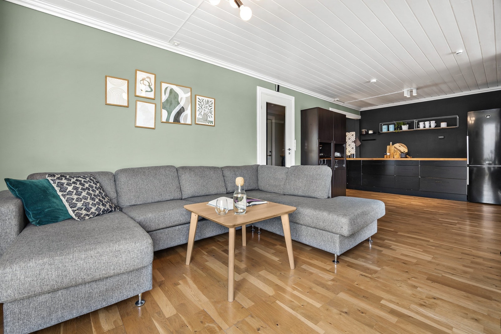 Praktisk stue i tilknytning til kjøkkenet med plass til stor sofagruppe. Galleribilde