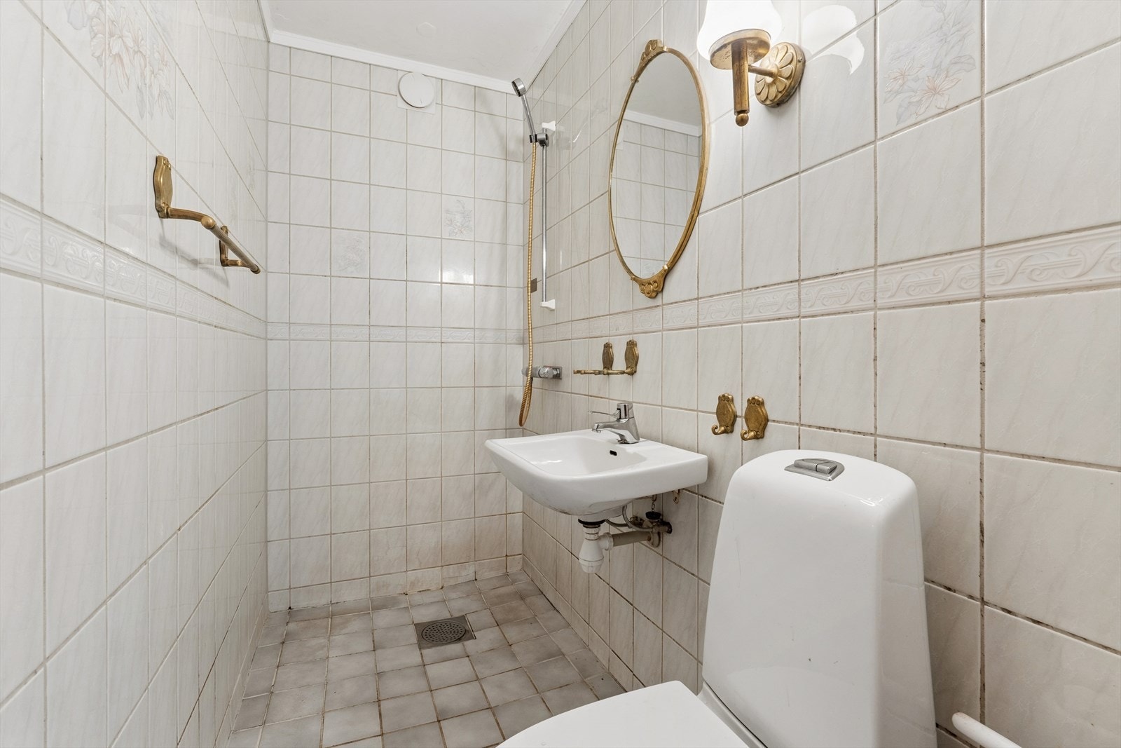 Badet er innredet med dusjløsning, servant og toalett. Galleribilde