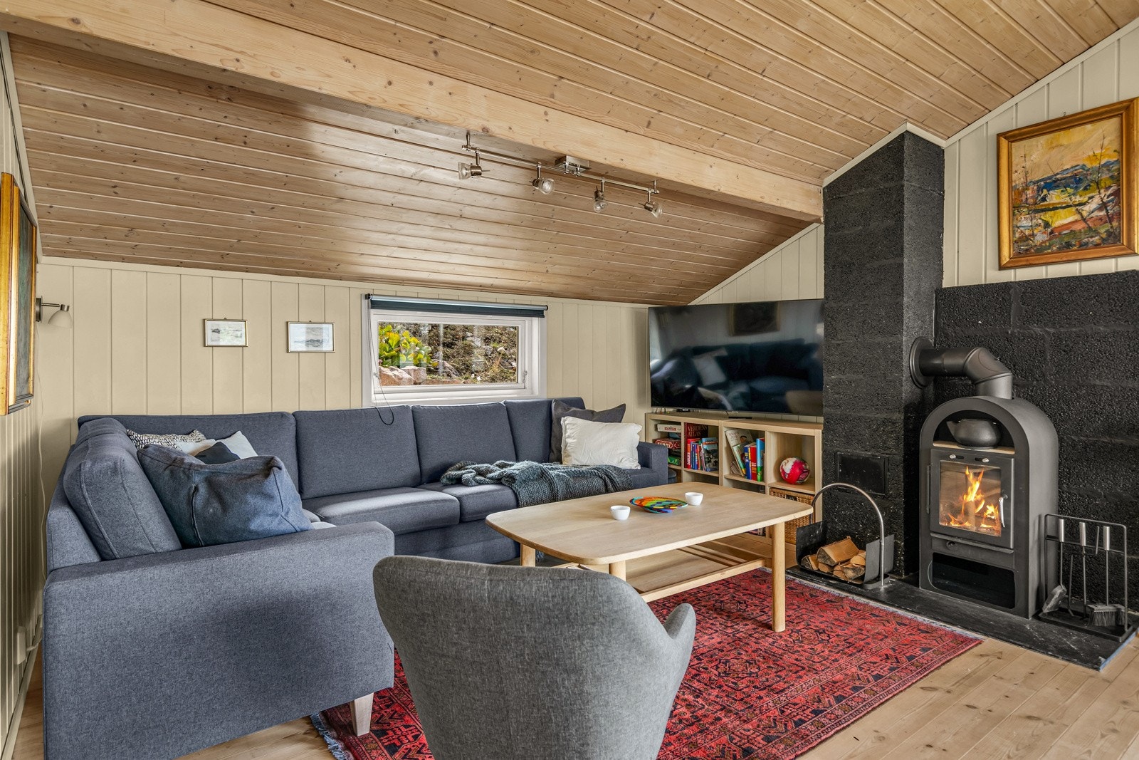 Det er både vedovn og varmepumpe montert i stuen. Galleribilde