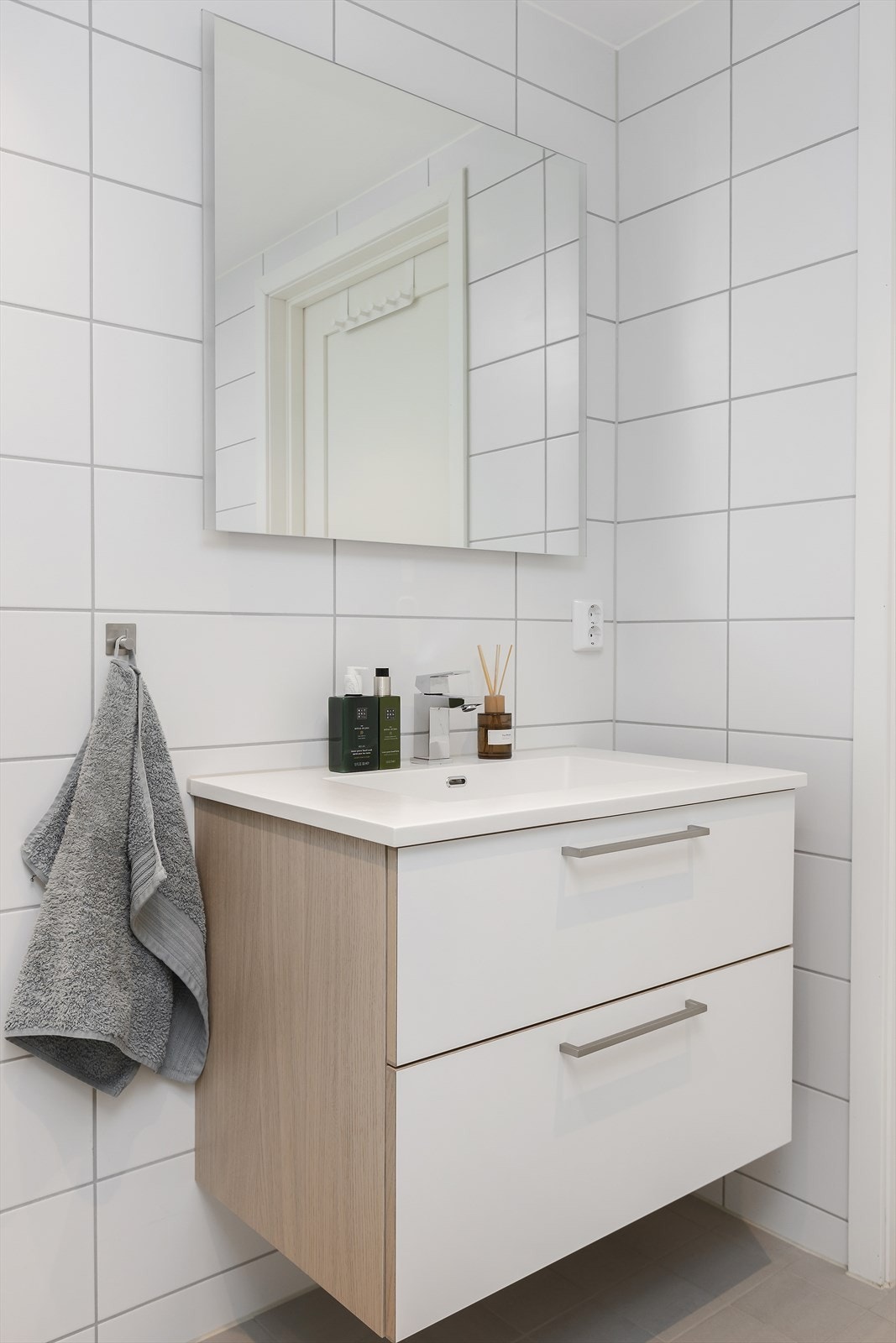 Badet har vegghengt toalett, servantinnredning og et dusjhjørne med regnfalls- og hånddusj. Galleribilde